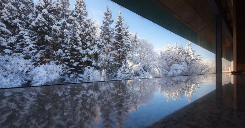 「界・津輕」溫泉池，窗外飄雪與溫暖蘋果溫泉交融的夢幻景色。  